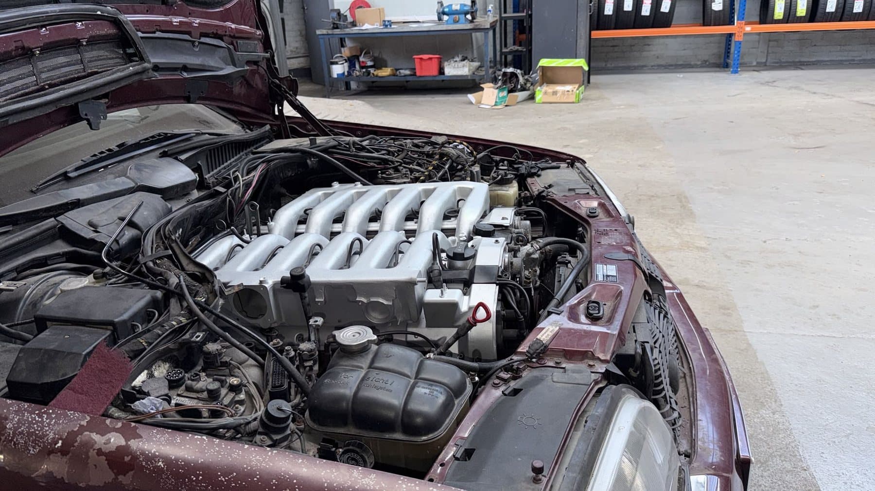 Technician working on an open engine bay during a repair